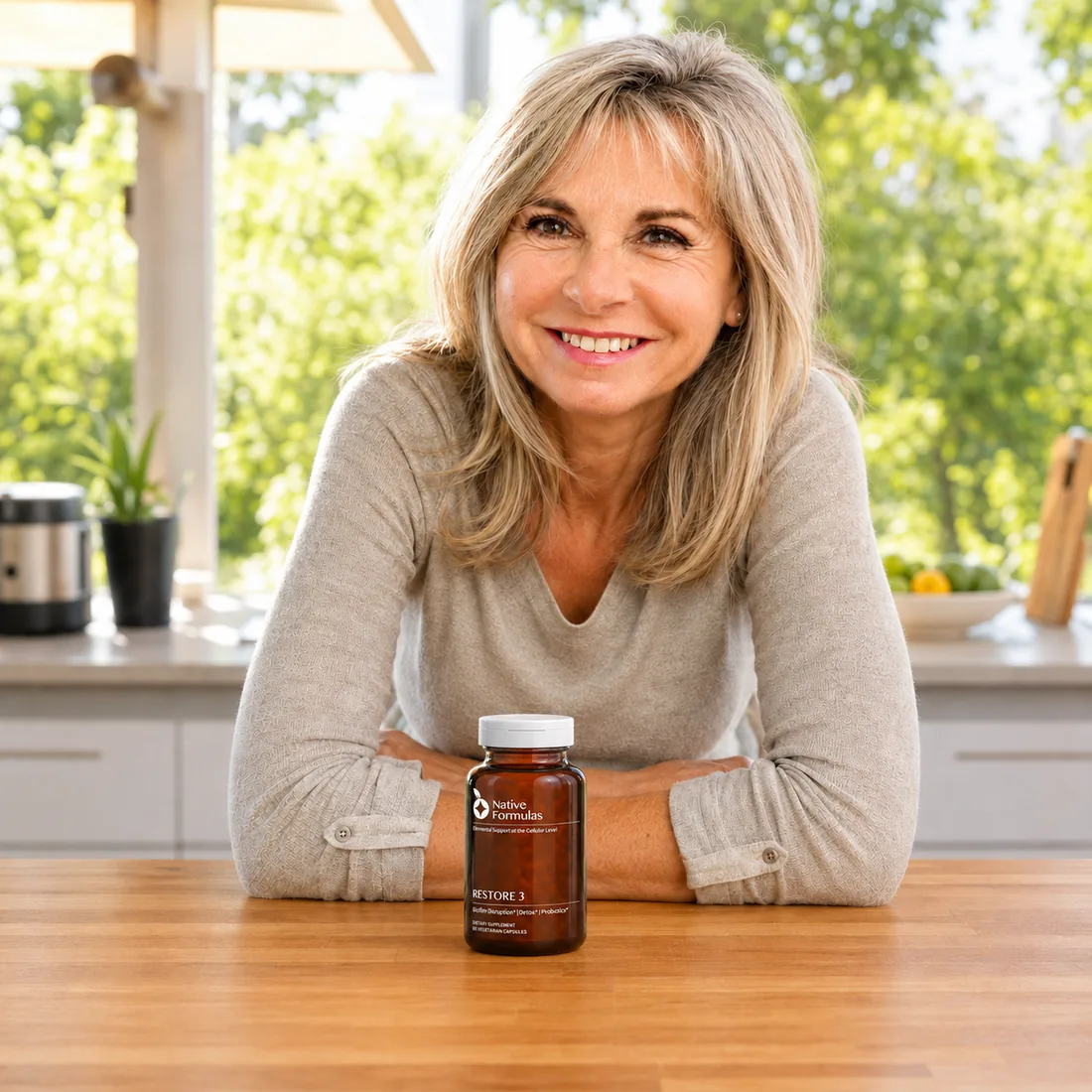 Woman smiling at a kitchen table with a bottle of Restore 3